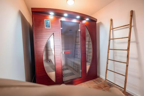 een houten lift met een spiegel in een kamer bij Casa Lounell, Piscine, Spa, Sauna in Graulhet