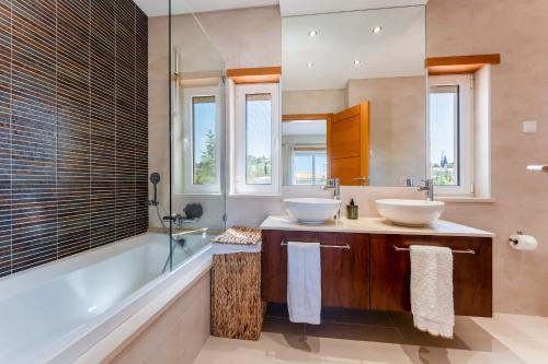 a bathroom with two sinks and a tub at Townhouse Sasha in Almancil