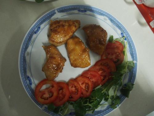 a plate of food with tomatoes and lettuce at Sao Mai Hotel in Cai Be