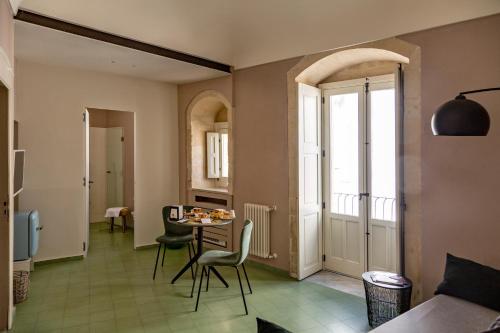 Casa dei Giurati في بالاتسولو أكريدي: مطبخ مع طاولة وكراسي في الغرفة