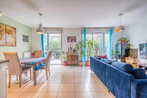 a living room with a blue couch and a table at Bright house ideal for exploring Bordeaux in Bordeaux