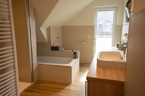 ein Badezimmer mit Badewanne und Waschbecken in der Unterkunft Haus Friesenkuss mit Hund in Wangerland