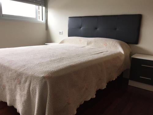 1 dormitorio con 1 cama blanca grande y ventana en Apartamento Alvaro, en A Illa de Arousa