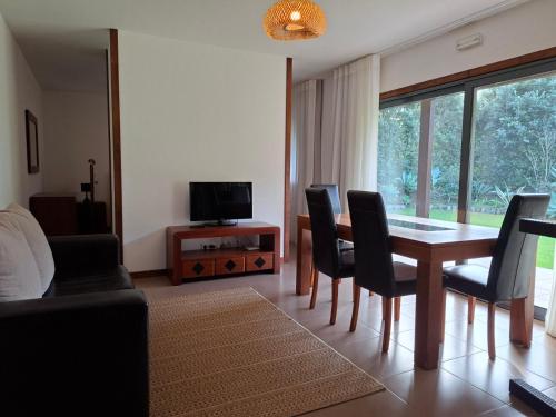a living room with a dining room table and chairs at Sítio da Assumada in Faja Grande