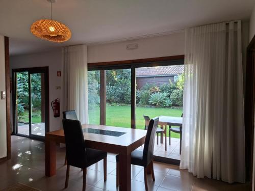 a dining room with a table and chairs and a window at Sítio da Assumada in Faja Grande