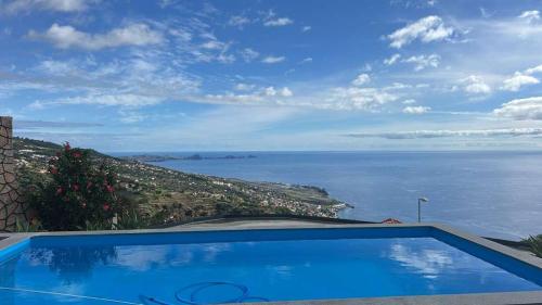 a swimming pool with a view of the ocean at Madeira Sunrise Villa in Gaula