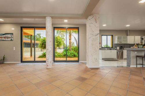 a large kitchen and living room with sliding glass doors at Madeira Sunrise Villa in Gaula