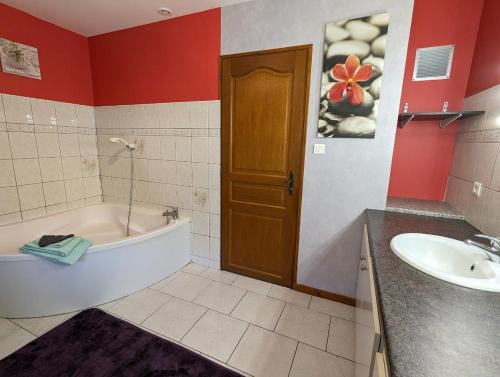 un baño con bañera y lavabo en Chambre d'hôtes du Savernay, en Chantraine