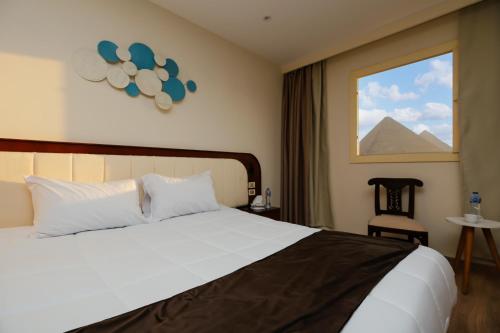 Una habitación de hotel con una cama y una ventana. en Sahary Pyramids View Hotel, en Giza