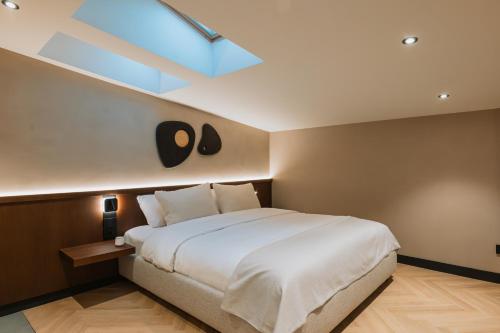 ブカレストにあるホテル トリアノンのベッドルーム(大きな白いベッド1台、天窓付)