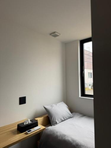 a small bedroom with two beds and a window at MOD 02 Kutchan Stylish Commons - NO PARKING 駐車場なし in Kutchan