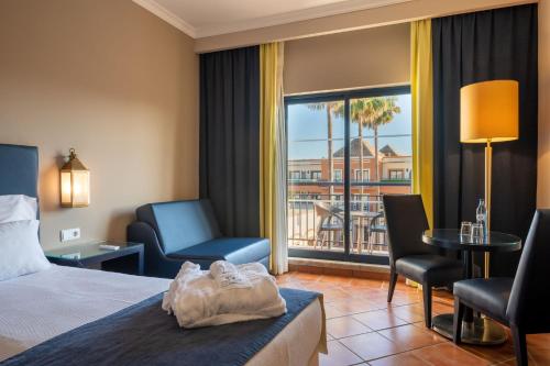 una habitación de hotel con una cama y un balcón en Vila Gale Tavira, en Tavira