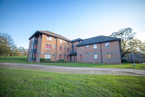 a large brick building with a grass field in front at University of Essex - Colchester Campus in Colchester