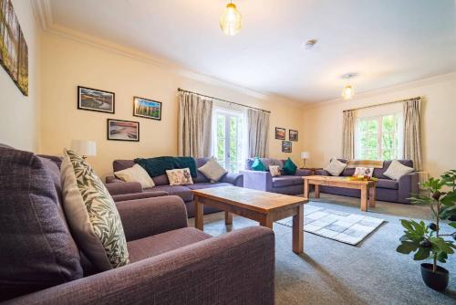 a living room with couches and a table at Cartref in Wales