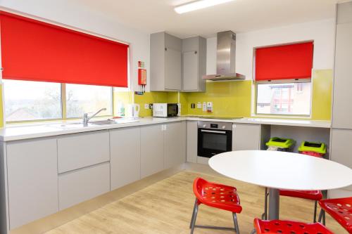 a kitchen with white cabinets and a white table and chairs at University of Essex - Colchester Campus in Colchester