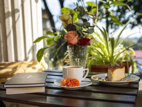 ein Tisch mit zwei Tellern Essen und einer Tasse Kaffee in der Unterkunft Pałac w Małkowie in Warta