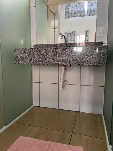 a bathroom with a counter with a sink and a mirror at HOTEL POUSADA POR DO SOL in Pato Branco