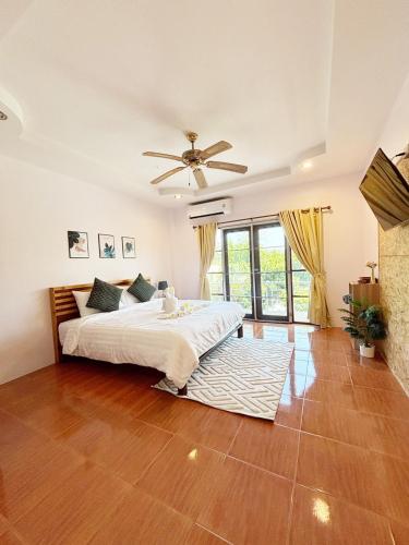 a bedroom with a bed and a ceiling fan at Sachi Home Villa Bangtao - Near Muay Thai and Beach in Ban Thalat Choeng Thale