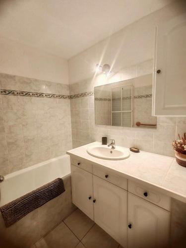 アブリエスにあるAppartement cozy - 4 à 6 personnesの洗面台とバスタブのある白いバスルーム