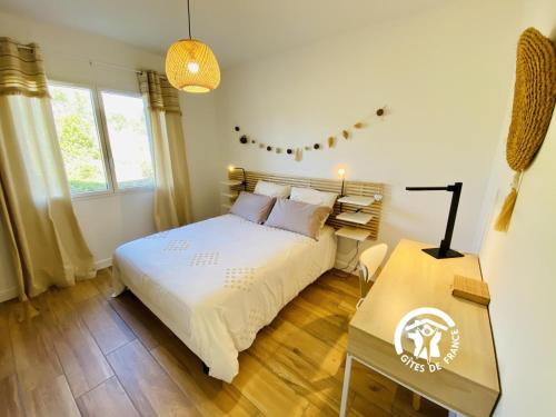 een slaapkamer met een wit bed en een tafel bij Le moulin de maquens in Carcassonne