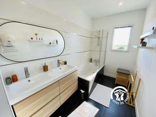 een badkamer met een wastafel en een spiegel bij Le moulin de maquens in Carcassonne