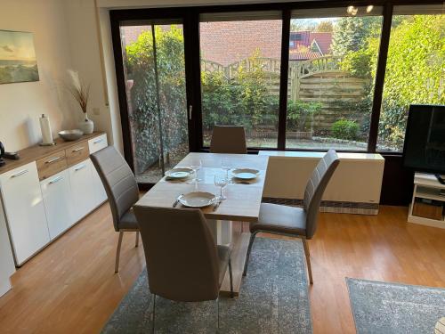 a kitchen and dining room with a table and chairs at Wohnung HaHü in Dangast