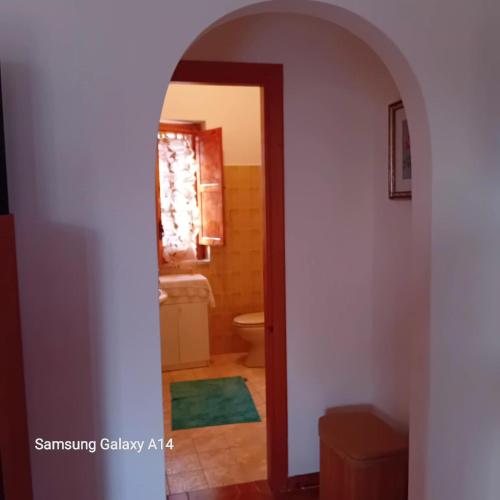 een boog die leidt naar een badkamer met een toilet bij Villa Armonia in Spigno Saturnia