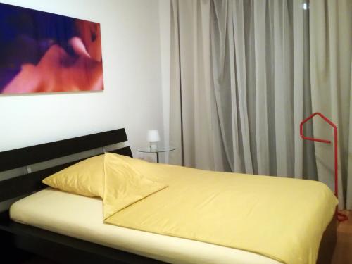 1 dormitorio con 1 cama con sábanas amarillas y una pintura en Art Apartment Scharitzerstraße, en Linz