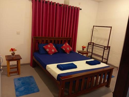 a bedroom with a bed with a red curtain at Kenashi Green Villa in Weligama