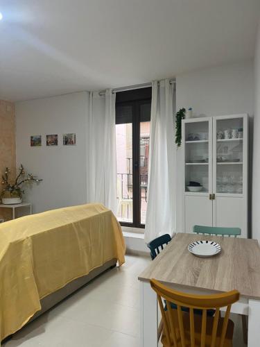 Un dormitorio con una cama y una mesa y una ventana. en Casa Mencía, en Plasencia