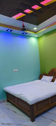 a bed in a room with green and blue walls at Royal inn in Patna