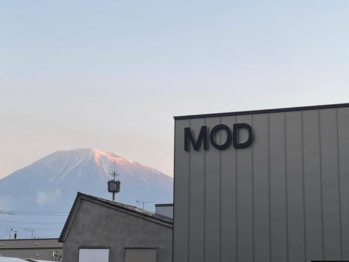 a snow covered mountain in the distance behind a building at MOD 02 Kutchan Stylish Commons - NO PARKING 駐車場なし in Kutchan