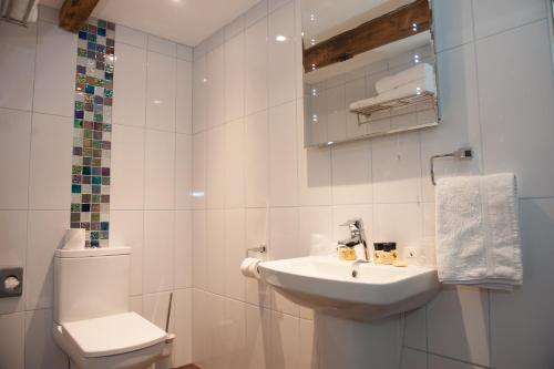 a white bathroom with a toilet and a sink at Hotel Forty One in Great Driffield