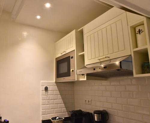 マラケシュにあるRiad Lilou Marrakechの白いキャビネットと電子レンジを備えたキッチン