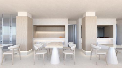 uma sala de jantar com mesas e cadeiras brancas em Kos Aktis Art Hotel em Cós