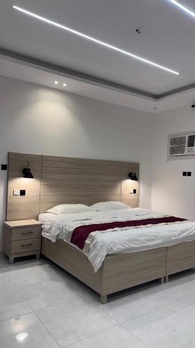 قصر الحياة للشقق المخدومة في القريّات: غرفة نوم بسرير كبير مع لوح رأس خشبي