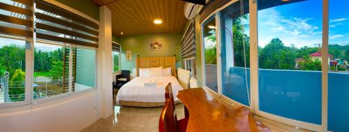 SaraTUBURAN Poolside的一间卧室配有一张床,阳台配有窗户