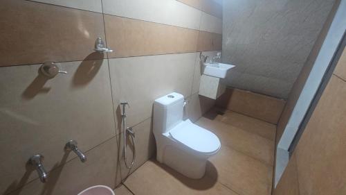 a bathroom with a white toilet and a shower at Pattaya Village in Kollam