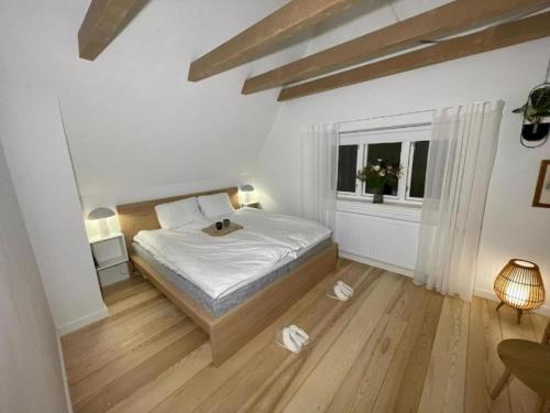 Una habitación blanca con una cama y una ventana en Modern & Unique property in Odense centrum - FREE PARKING, en Odense