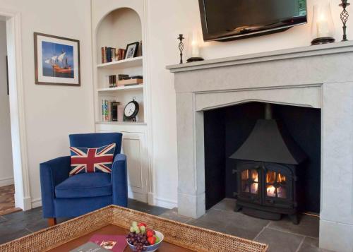 a living room with a fireplace and a blue chair at Cary Arms & Spa in Torquay