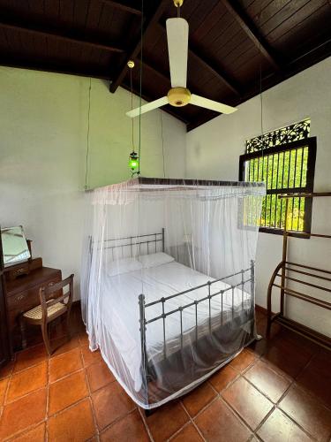 a bedroom with a bed with a mosquito net at Paddy View Villa in Pedinnoruwa