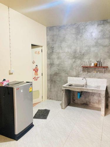 a kitchen with a sink and a refrigerator at Pizza classic resort kohjum in Ban Ko Phrao