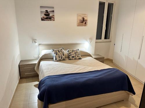 een slaapkamer met een bed met blauwe lakens en kussens bij Nala & Leo central Seaview Apartment in Lerici