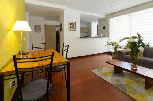 un soggiorno con un tavolo e un divano di Suites Metropoli Edificio Torino a Quito