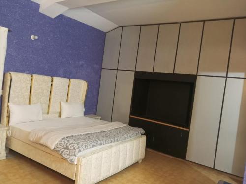 um quarto com uma cama e uma TV de tela plana em Hotel Grand Orchard Two em Lahore