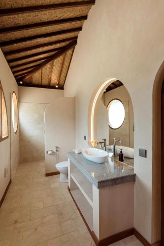 a bathroom with a sink and a toilet at Uludream in Uluwatu