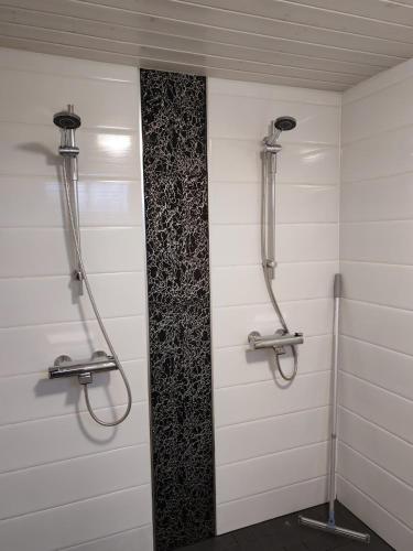 ein Badezimmer mit weißen Wänden und zwei Duschen in der Unterkunft Joentörmä Cottage in Merikarvia