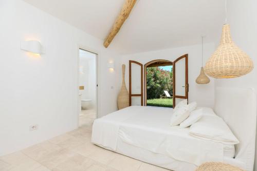 um quarto branco com uma cama e um espelho em Apartment In Porto Cervo em Porto Cervo