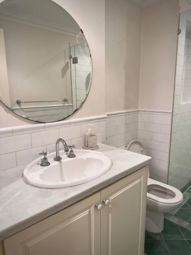 a bathroom with a sink and a mirror and a toilet at King Street Retreat in Perth