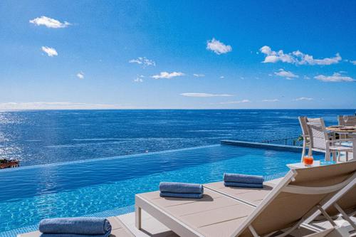 a swimming pool with a view of the ocean at Villa Infinityviews Madeira in Câmara de Lobos